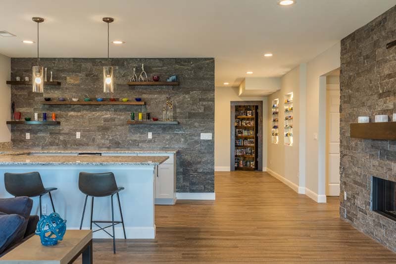 Basement bar with a stone wall and a fireplace