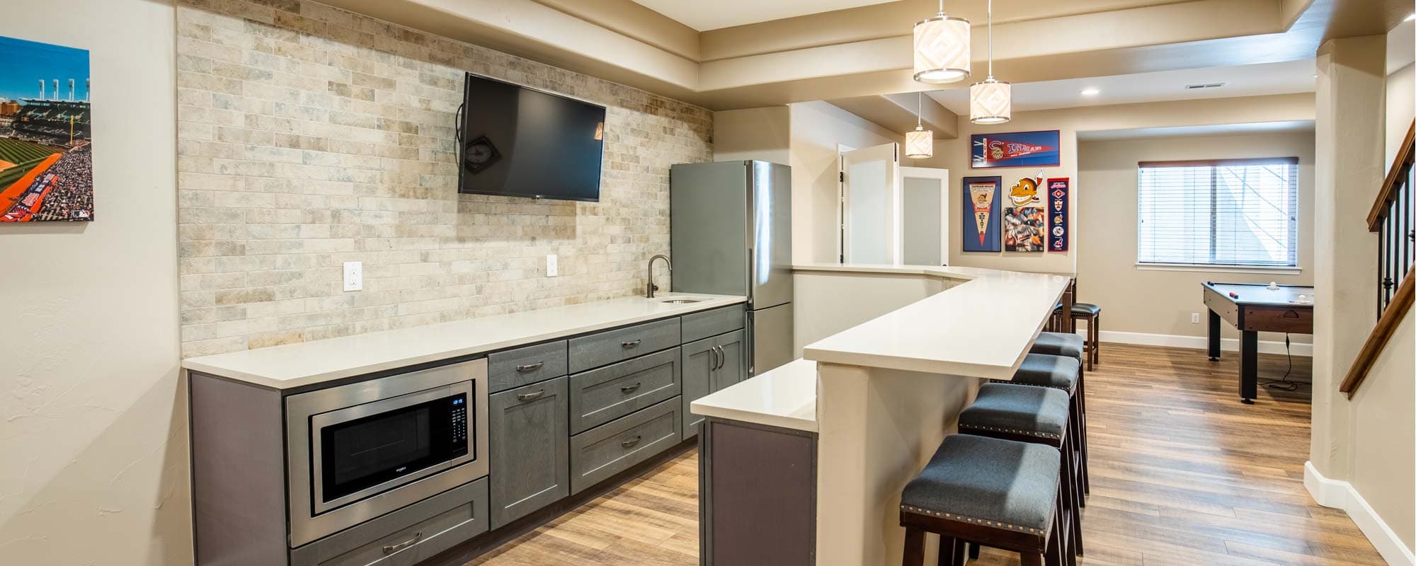 Finished basement with a kitchenette, a bar and a game table