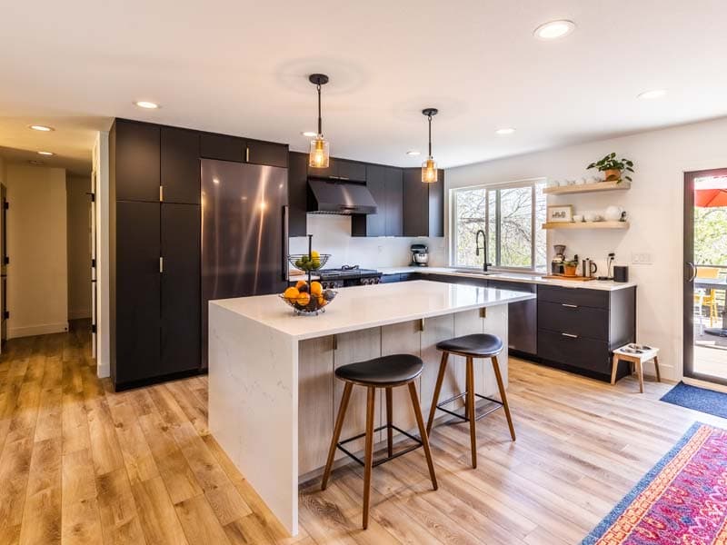 Remodeled kitchen with dark cabinets and a quartz island
